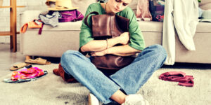 woman holding an item sadly, sorting through personal belongings after a death